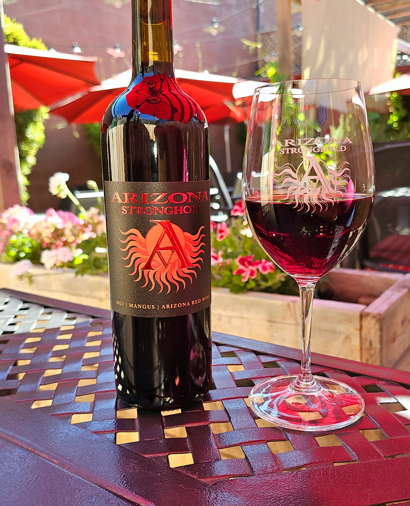 Arizona Stronghold 2021 Mangus red wine bottle and glass on table.