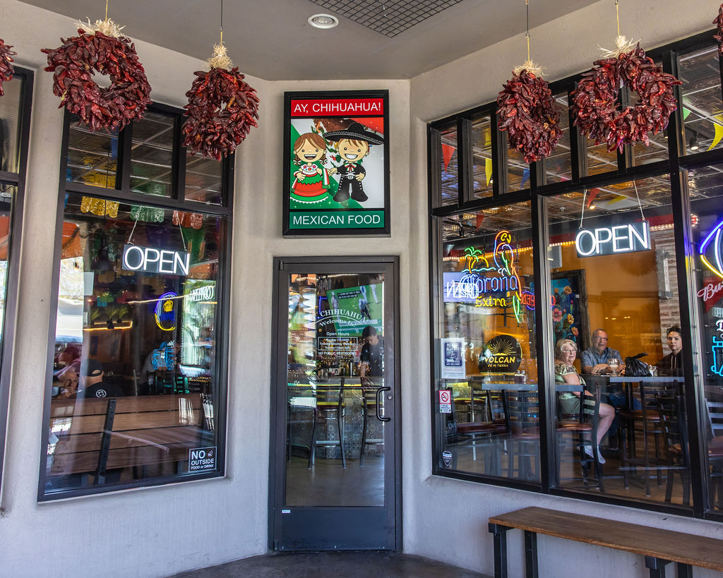 Colorful Mexican restaurant entrance with 'Ay Chihuahua!' sign and open neon lights