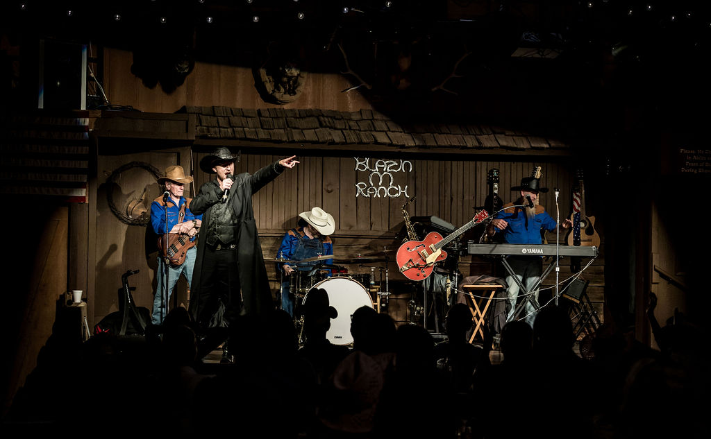 Live country band performing at rustic-themed venue with audience watching.