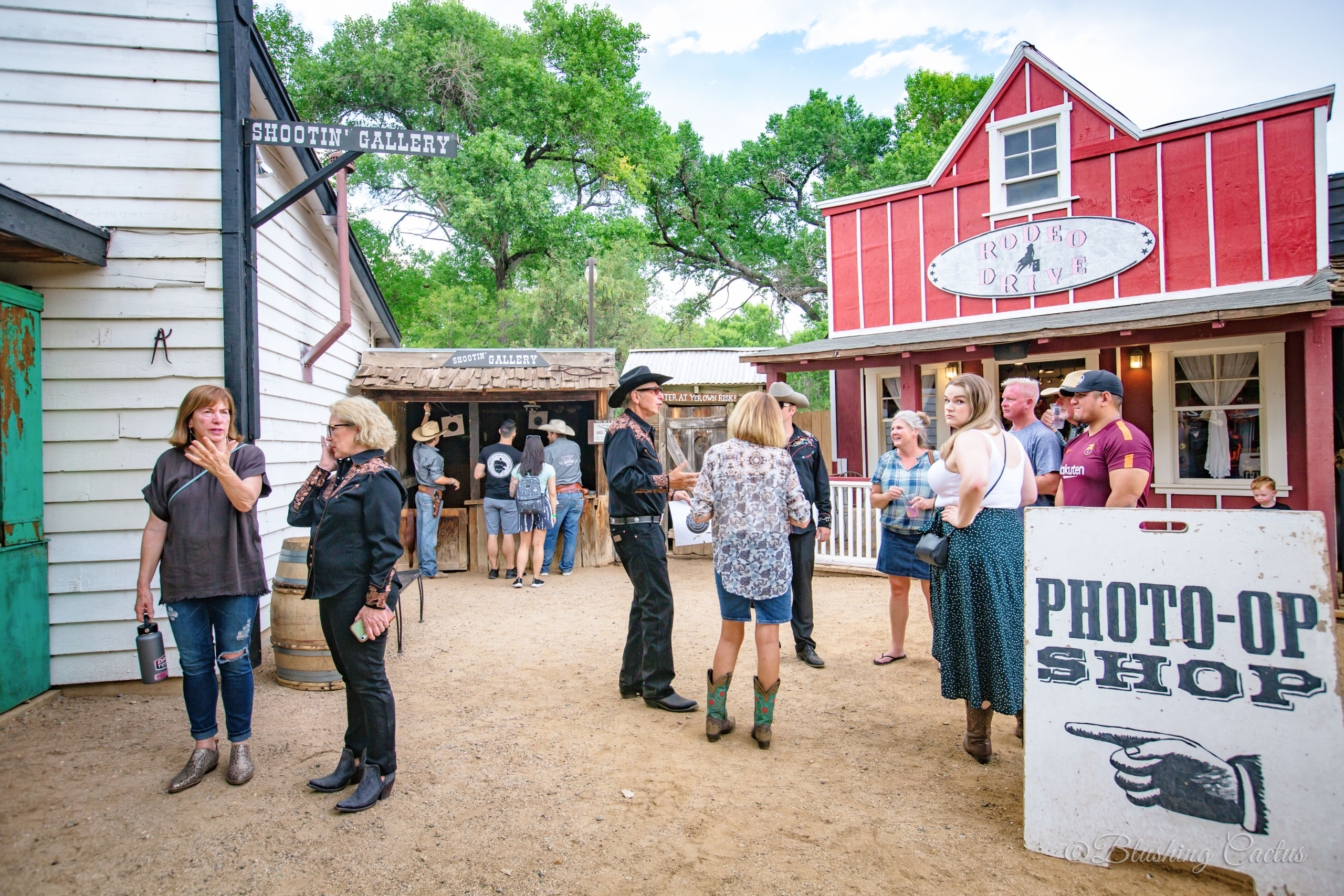 Group of people visiting Old West-themed shops and attractions at a tourist location.