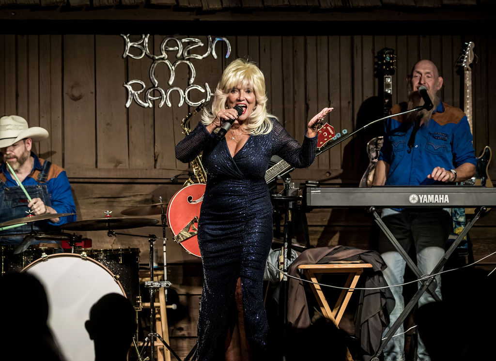 Country music performer singing live on stage with band members