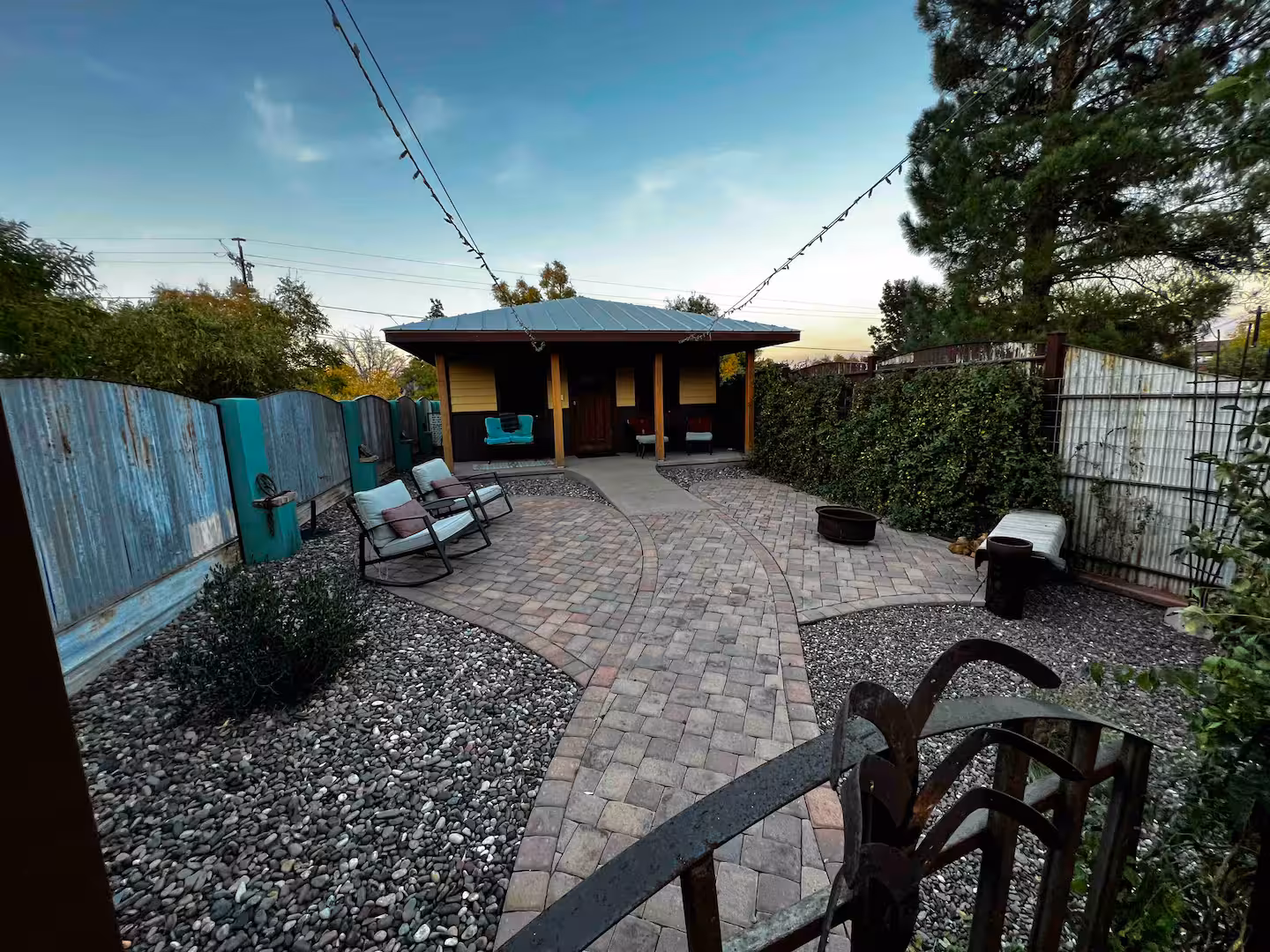 Cozy backyard patio with chairs, gravel, and small backyard shed