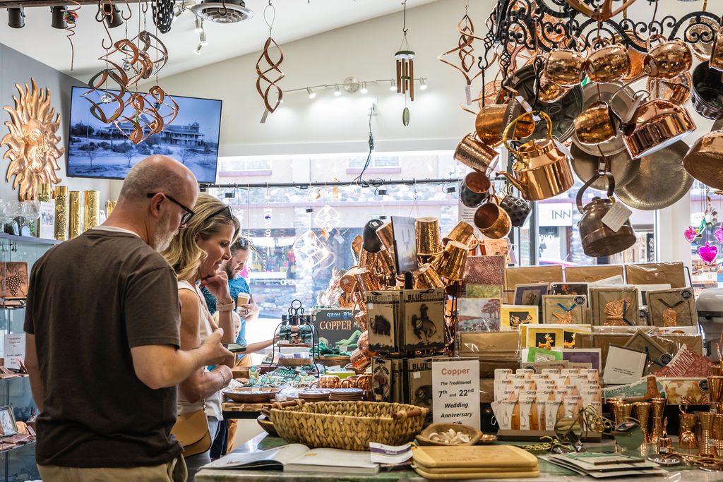 Couple browsing copper wedding anniversary gifts in artsy shop.