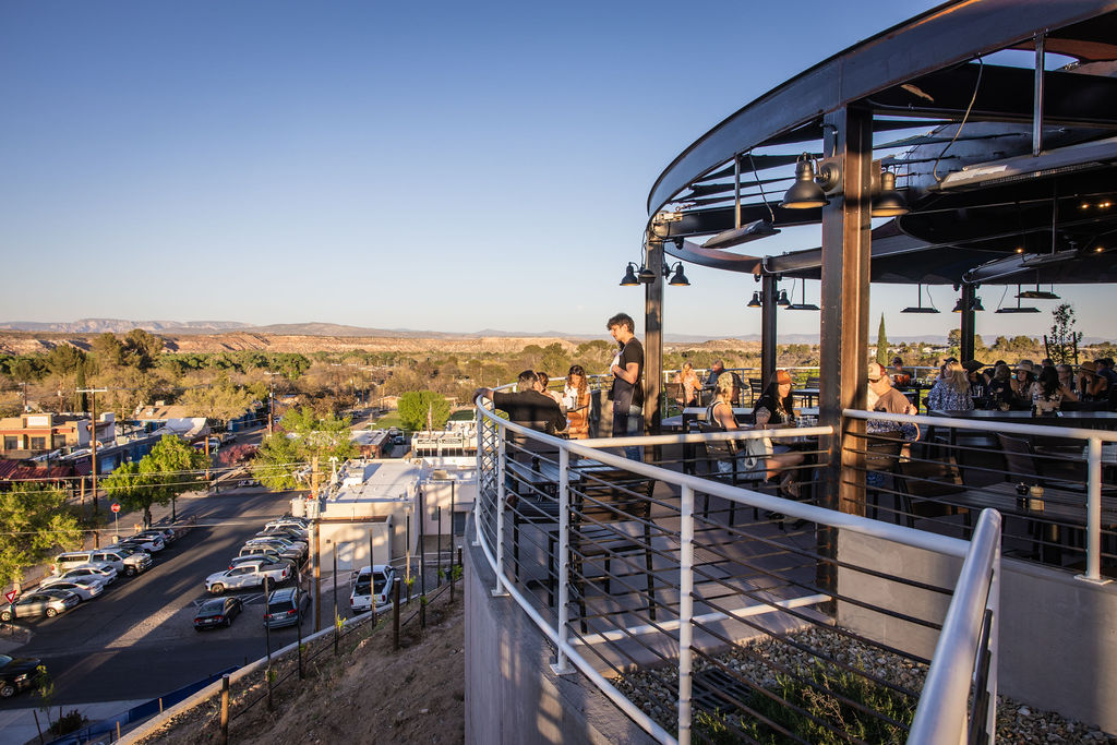 Rooftop bar overlooking city with people enjoying sunset views