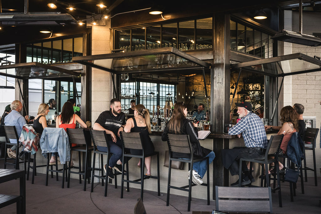 People socializing at modern rooftop bar with ocean view