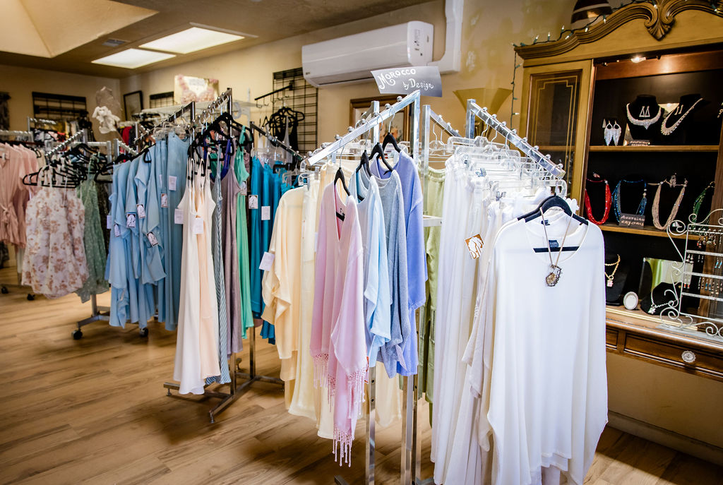 Elegant women's dresses displayed on racks in boutique store.