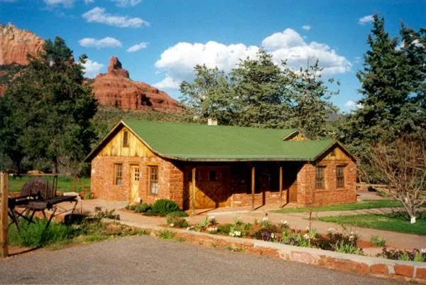 Charming rustic cabin with green roof near scenic red rock formations