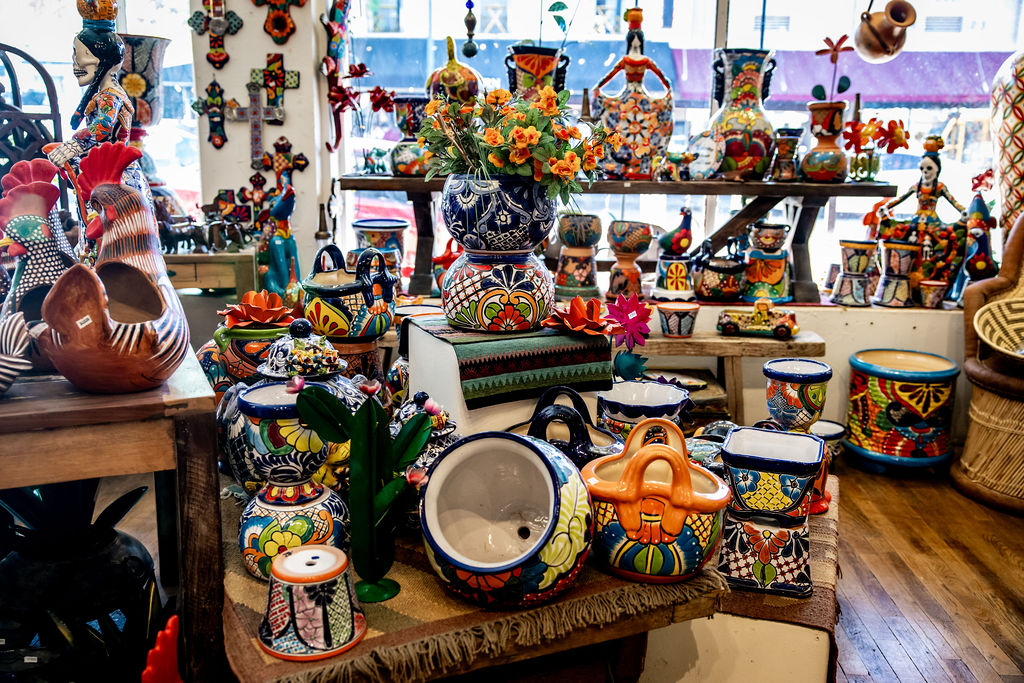 Colorful hand-painted Mexican pottery display with vases, jugs, and decorative items