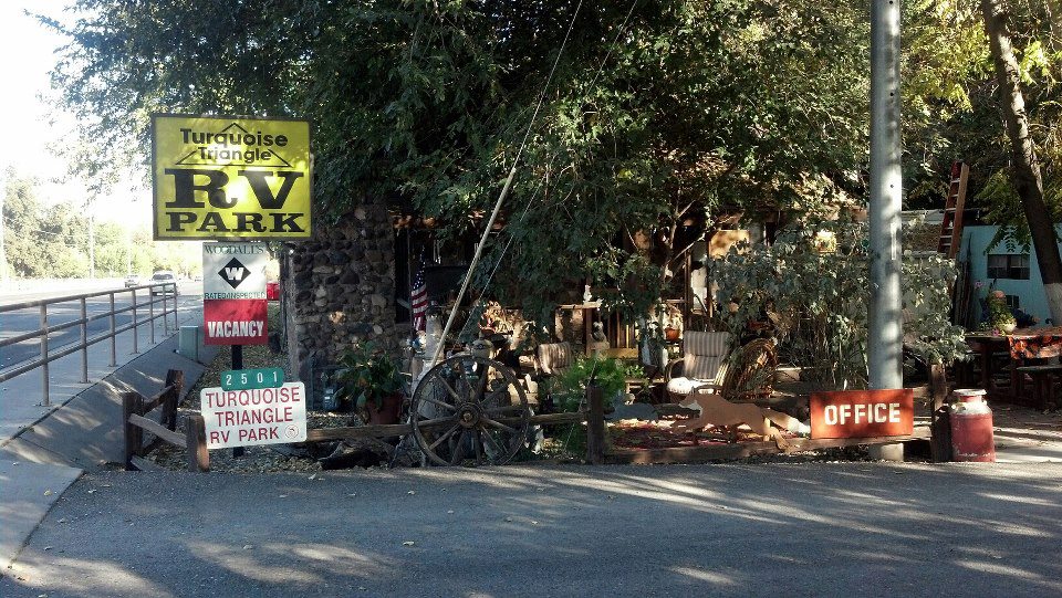 Turquoise Triangle RV Park entrance with vacancy sign, rustic decor, and office.