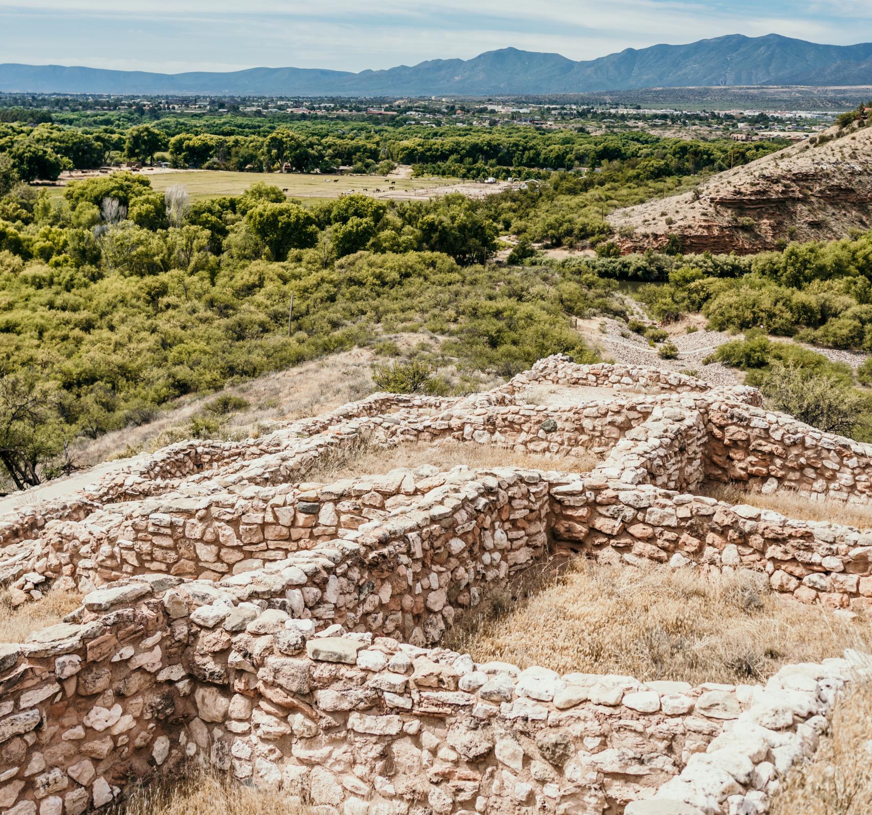 Ancient stone ruins with scenic mountain and valley landscape under clear blue sky