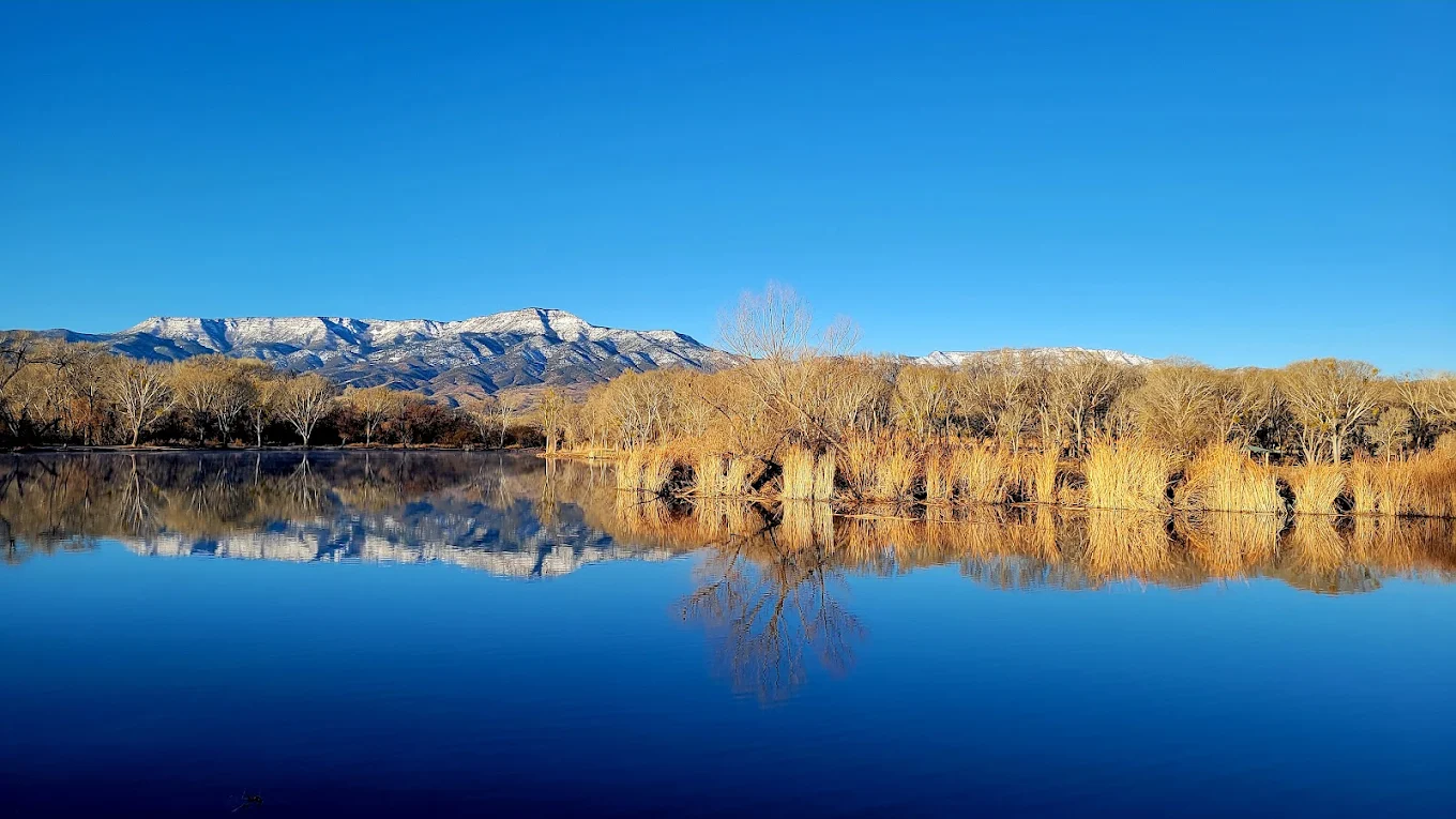 Serene winter landscape with snow-covered mountains and reflective calm lake