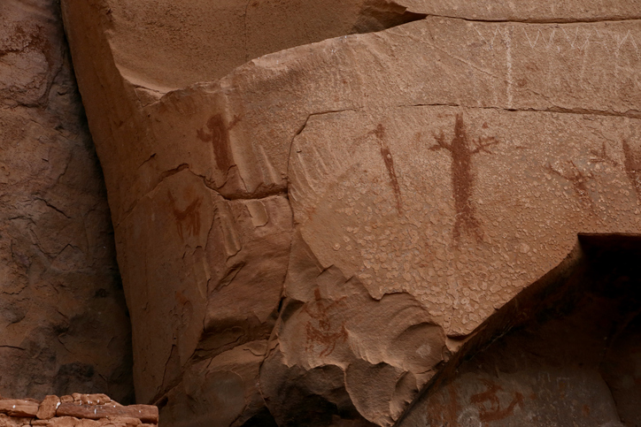 Ancient rock carving of human figures on sandstone cliff