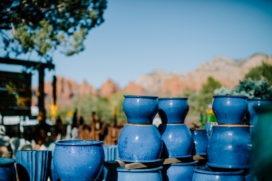 Bright blue ceramic jugs displayed outdoors with scenic mountain background