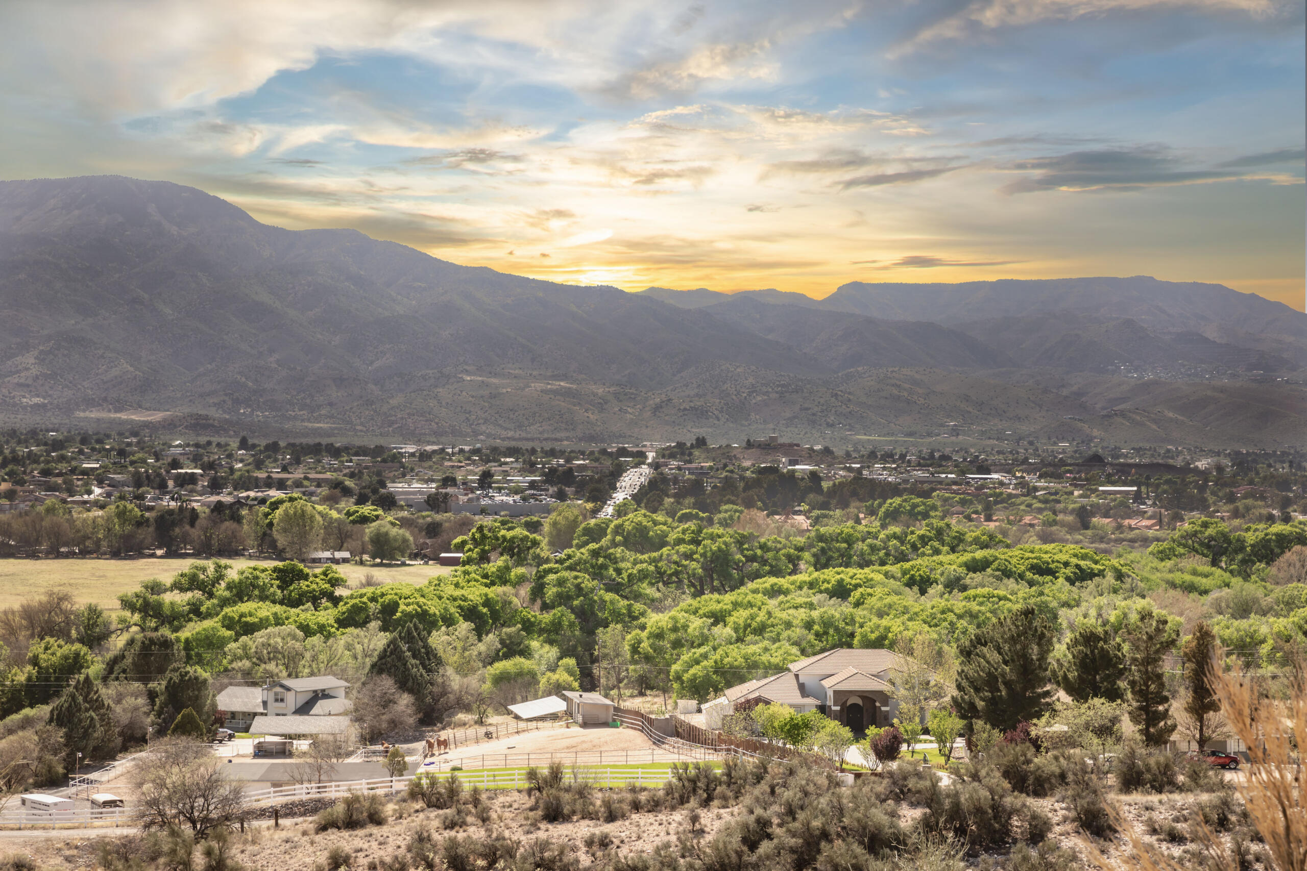 Sunset over suburban homes and mountains with scenic valley view.
