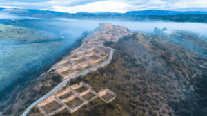 Ancient fortress ruins atop misty mountain with scenic hiking paths