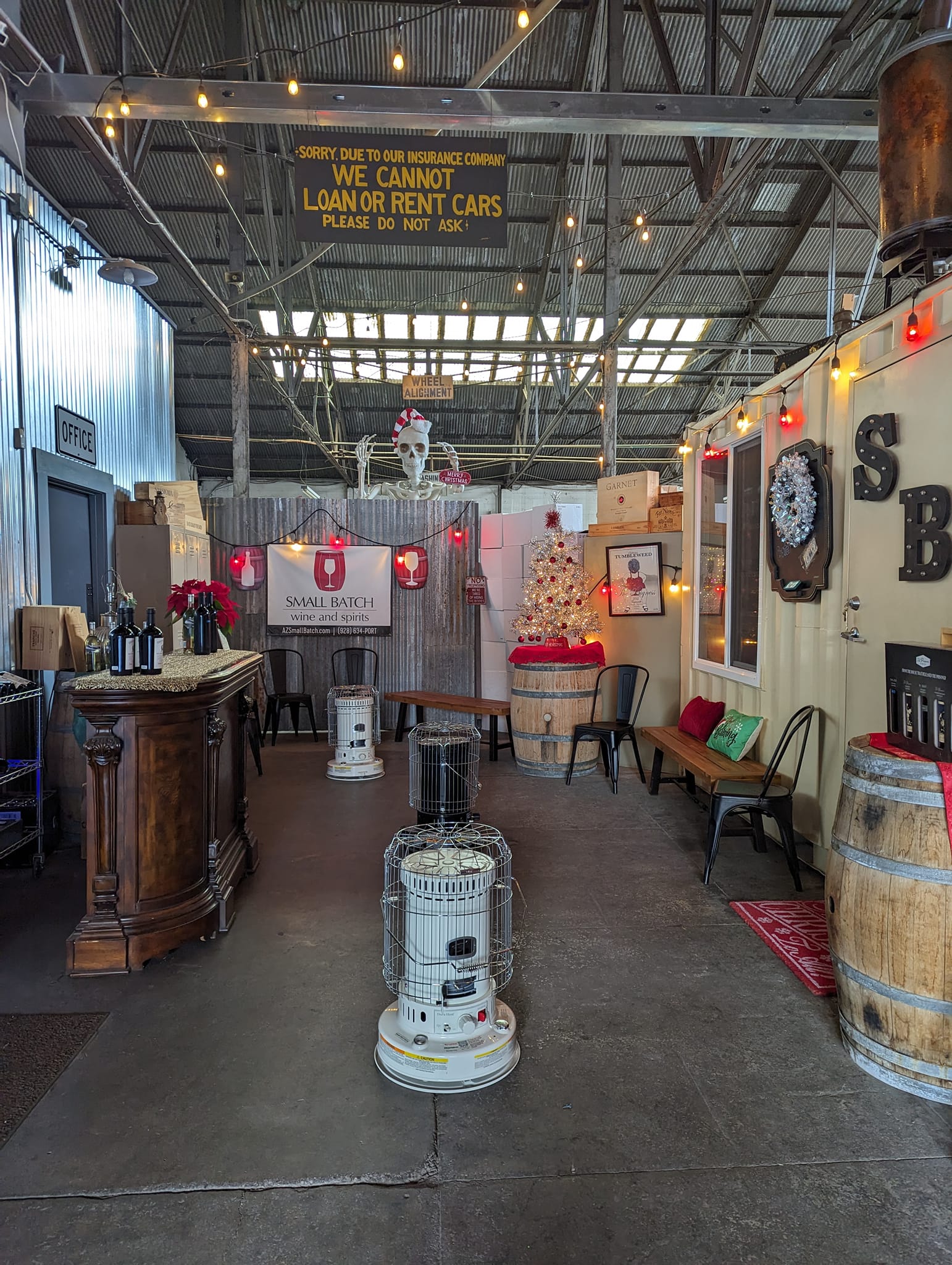 Cozy small-batch winery and spirits shop with festive holiday decor and heating units inside.