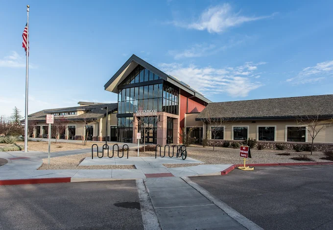Modern government office building with parking lot and American flag