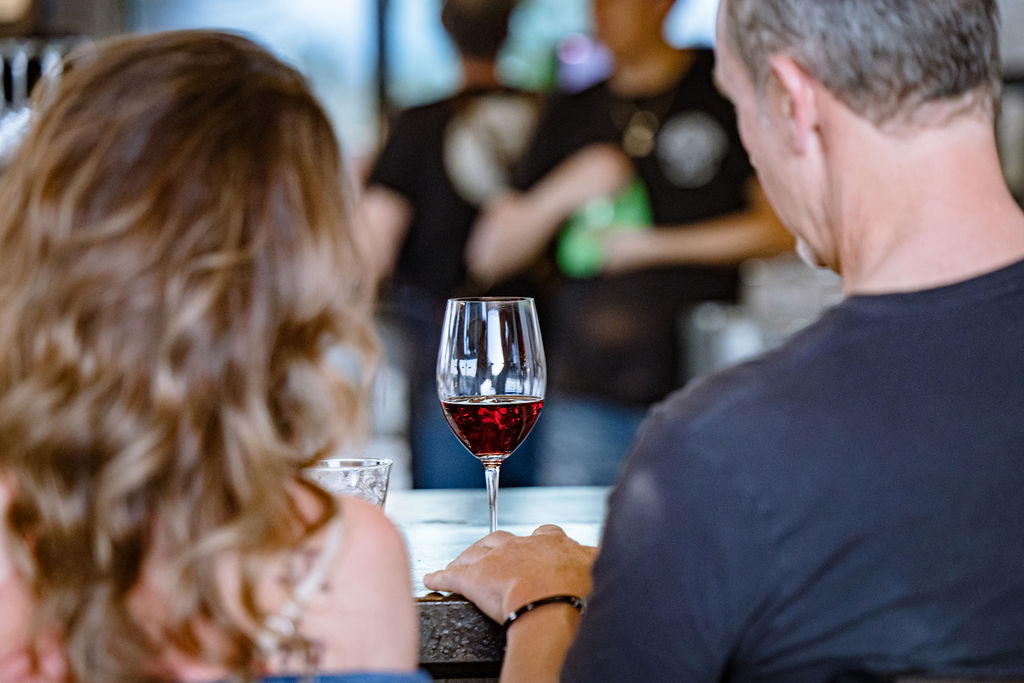 Two people clinking glasses of red wine together