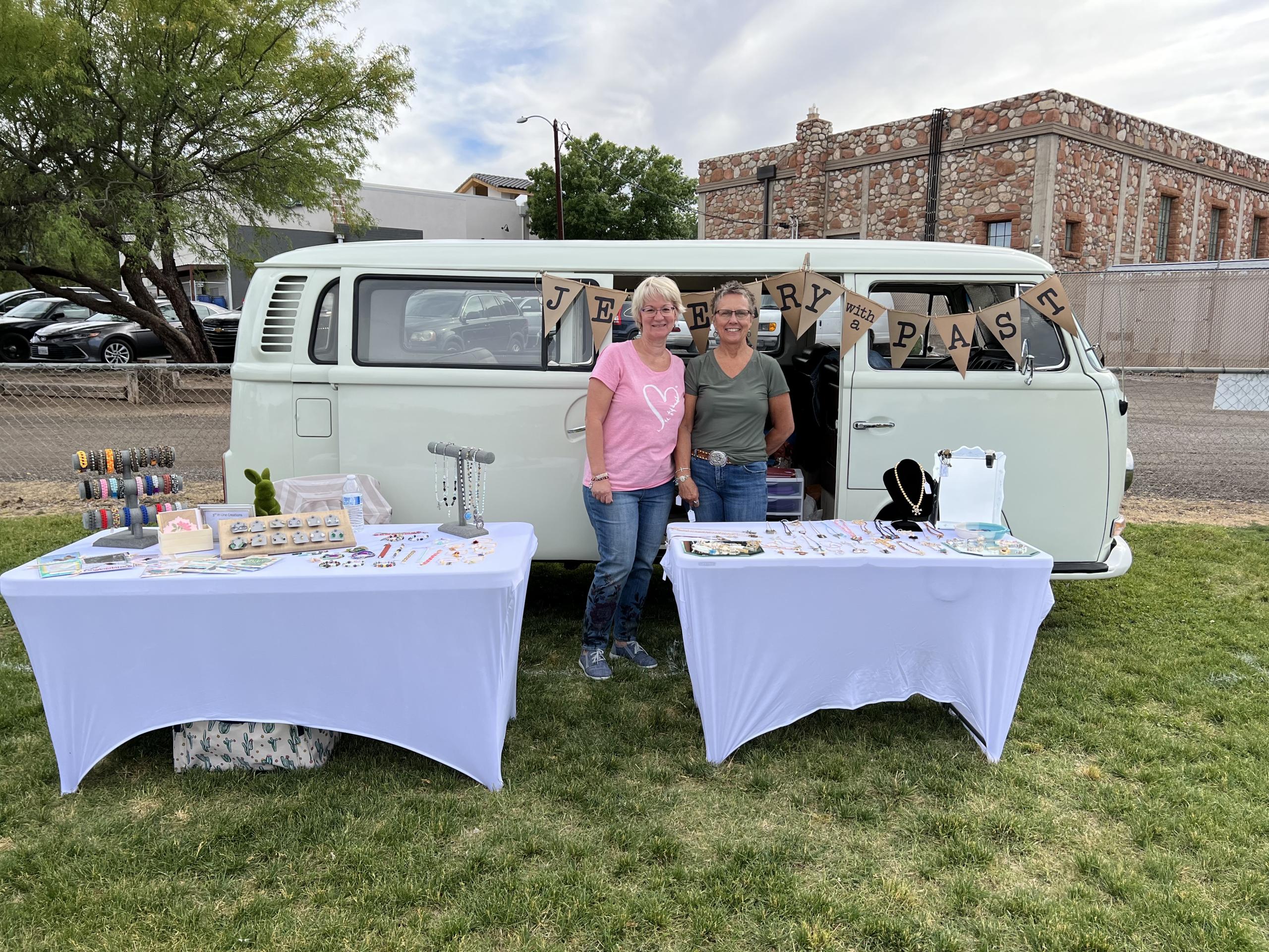 Two people setting up ice cream cart at outdoor event