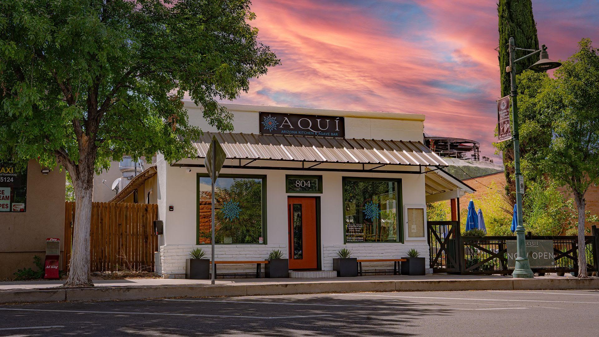 Aqui Arizona restaurant with orange door and sunset sky