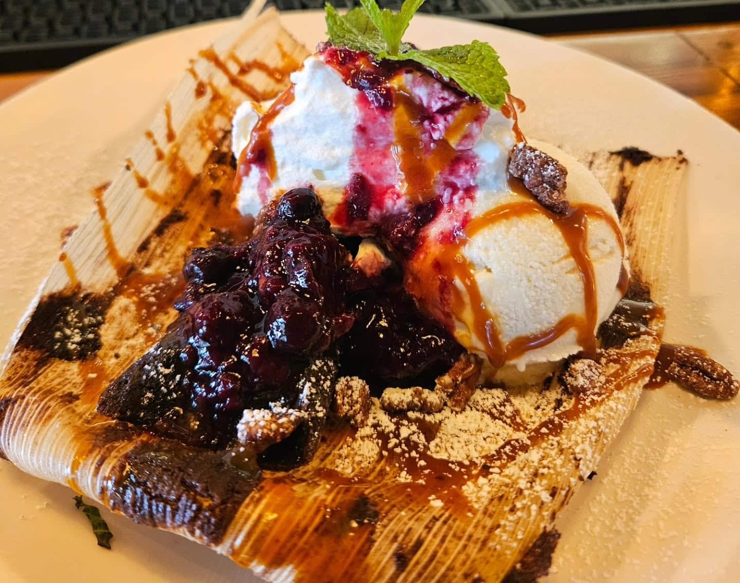 Sweet corn tamale with ice cream, berries, whipped cream, and caramel sauce.
