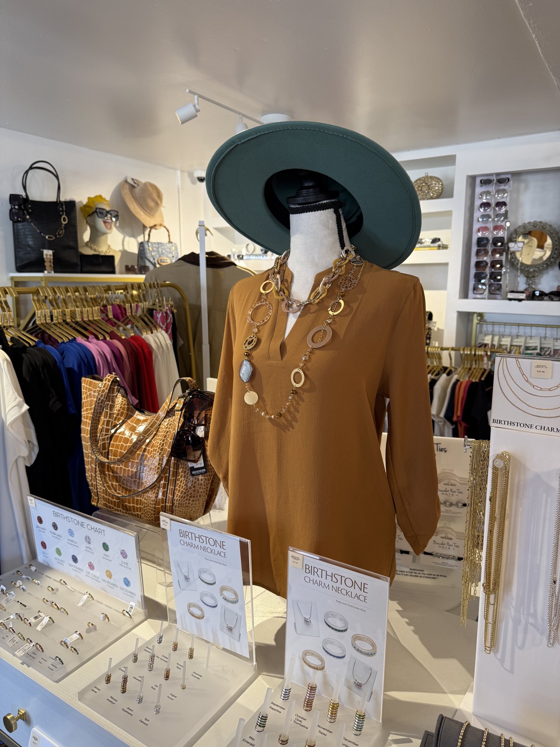 Boutique display with hat, jacket, jewelry, and colorful clothing